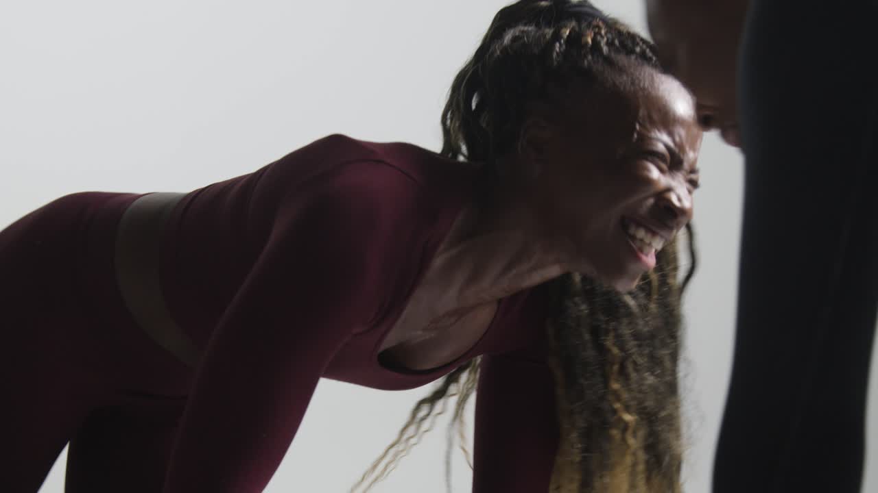 fotografía de estudio de dos mujeres vestidas con ropa de gimnasia frente a frente haciendo ejercicio 6