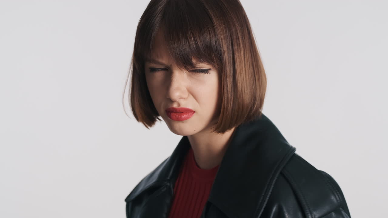 혐오스러운 표정을 가진 젊은 여성이 포즈를 취하고 있습니다.