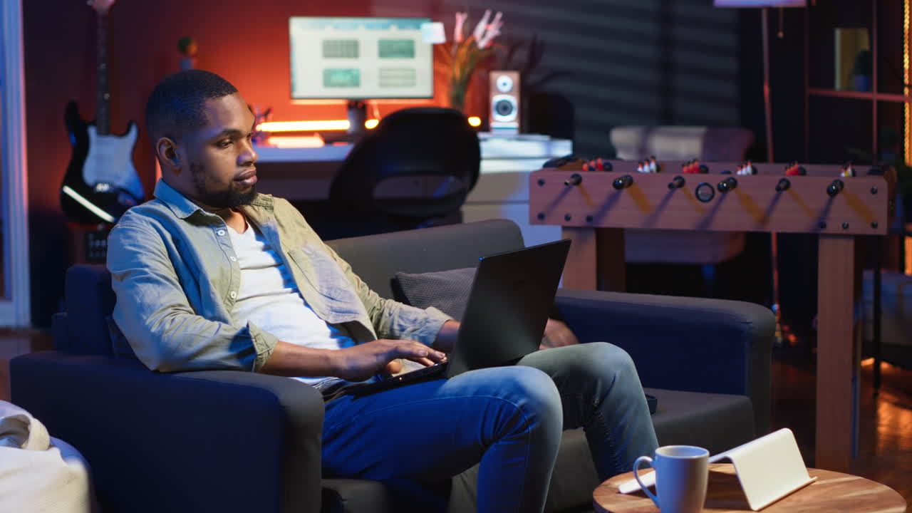 Video verticale: Persona afroamericana che partecipa a un webinar sul suo PC wireless nel suo soggiorno