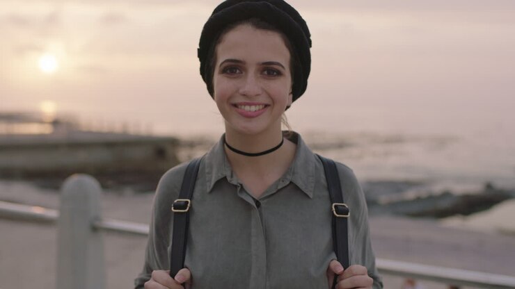 ritratto di una bella ragazza in riva alla spiaggia sorridendo allegra posando guardando la telecamera