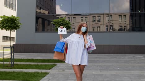 Mädchen-In-Schutzmaske-Mit-Einkaufstüten,-Die-Während-Der-Covid-19-Pandemie-Die-Aufschrift-„Sale“-Zeigen