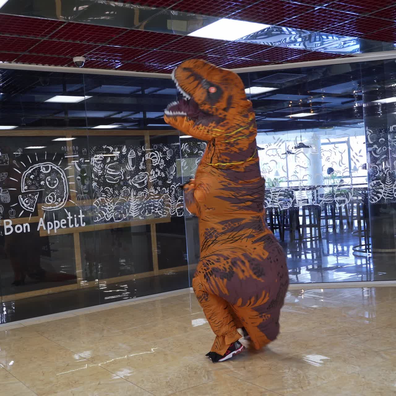 Animator in dino costume walking in mall. Halloween funny character shopping