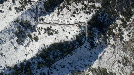 aerial view of winding road in snowy mountains