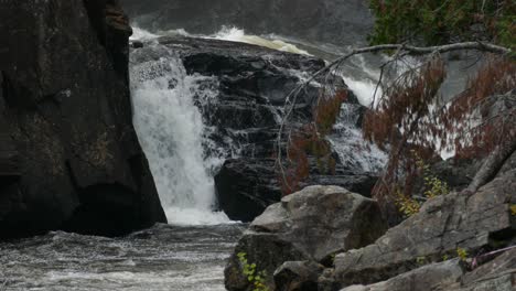 Agua-Salpicando-En-La-Distancia-Mientras-Cae-En-Cascada-Por-Algunas-Piedras-Impresionantes