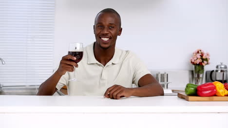 Man-tasting-red-wine-in-a-kitchen