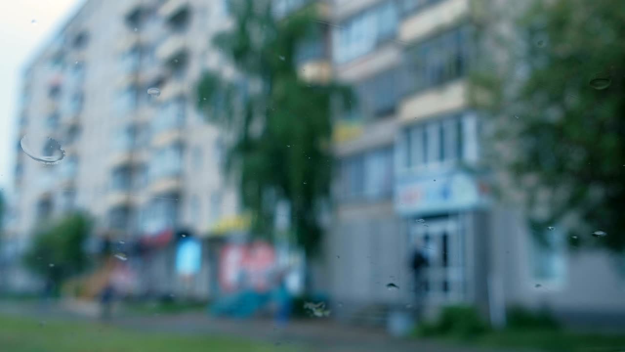 비가 내리는 차 창문에서 도시의 풍경. 흐릿하다.