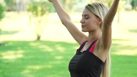 Smiling-woman-practicing-yoga-exercise-in-summer-park.-Fitness-a-lifestyle