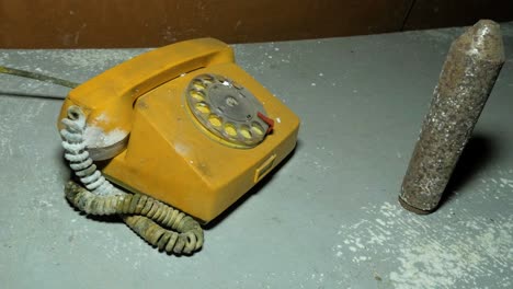 old yellow telephone inside the abandoned soviet underground bomb shelter, old soviet cold war bunker, apocalypse, medium handheld shot