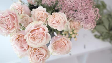 moving over a bouquet of pink roses being processed by a florist