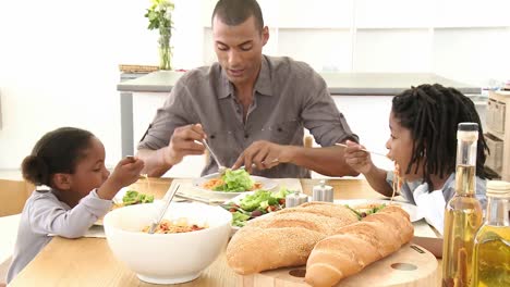 Vater-Und-Kinder-Essen-Nudeln-Und-Salat-Im-Wohnzimmer