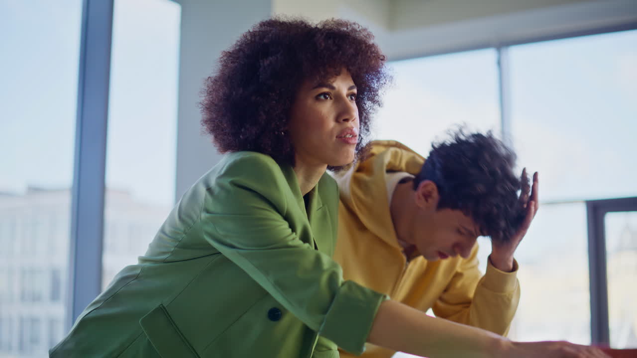 Fashion workers worried project failure reading news laptop in studio closeup