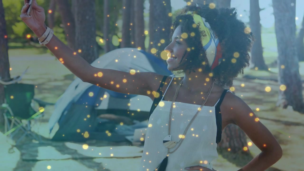 Woman checking phone, raising phone and posing for travel content with golden particles floating