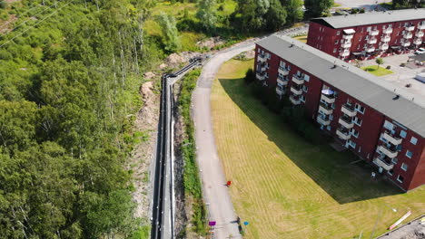 Infraestructura-De-Tuberías-De-Calefacción-En-Un-Sitio-De-Construcción-En-Una-Zona-Residencial,-Retroceso-Aéreo