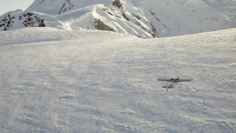 seguimiento aéreo pequeño avión volando sobre la montaña cubierta de nieve