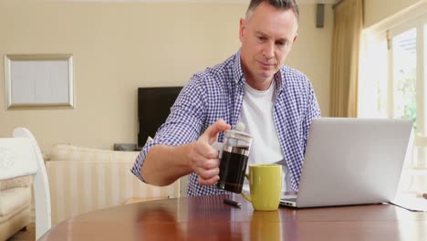 hombre maduro usando computadora portátil mientras toma café 4k