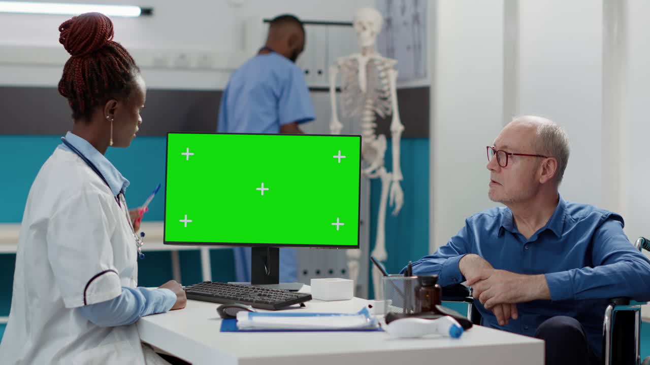 Doctor and patient with computer green screen in clinic