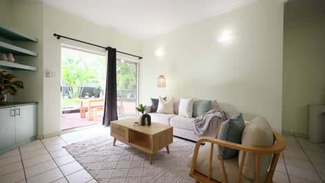 small modern tiled apartment loungeroom staged with wooden coffee table and arched art sculpture under braided rug