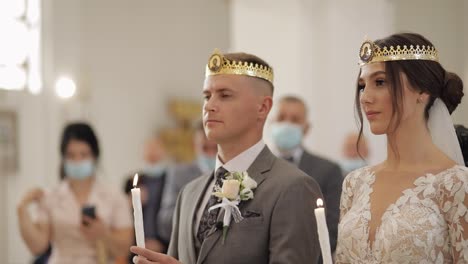 Los-Recién-Casados,-La-Novia-Y-El-Novio-Están-De-Pie-En-La-Iglesia,-Sosteniendo-Velas-En-Sus-Manos.-Ceremonia-De-Boda