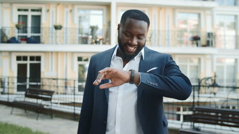 smiling black man checking time outdoors