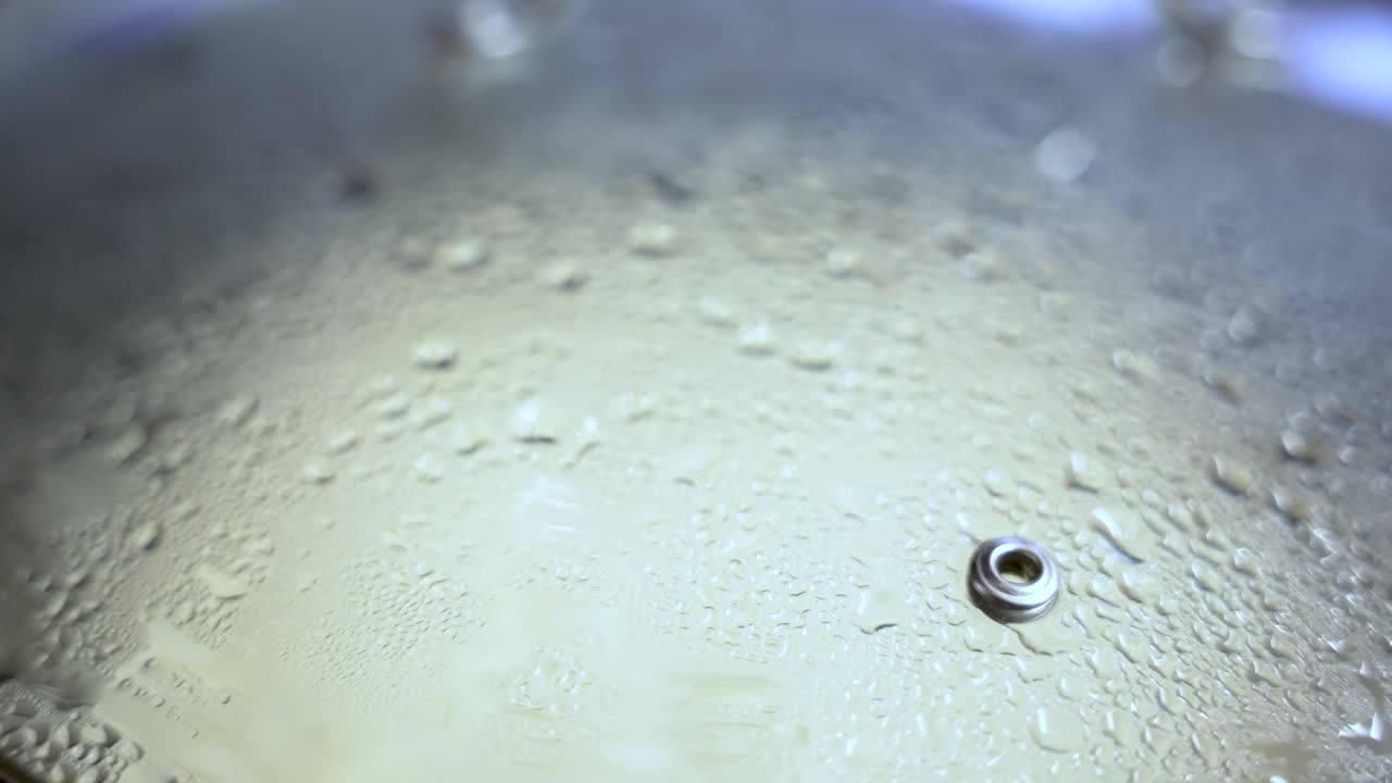 Close up of steam droplets forming on a pan lid during cooking, creating a textured pattern of condensation