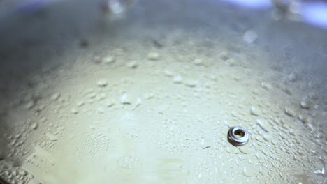 close up of steam droplets forming on a pan lid during cooking, creating a textured pattern of condensation