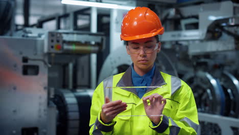 focused engineer using tablet with digital glass near factory constructions.