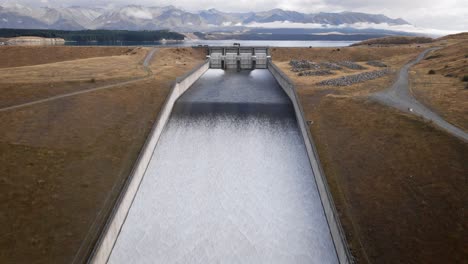 water running down ramp at hydro electricity facility near glacial lake in new zealand