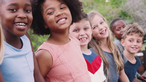 Portrait-Of-Children-Standing-On-Climbing-Frame-With-Friends-In-Park