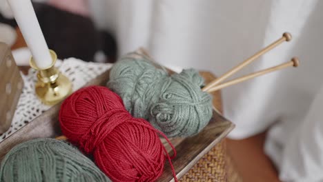 yarn balls and knitting needles on tray