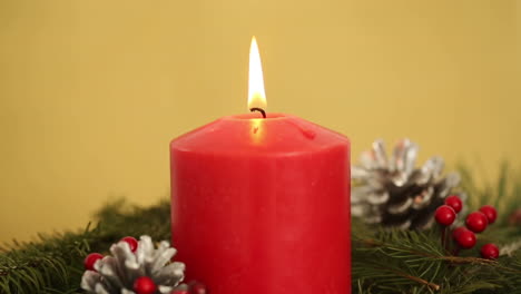 vela roja con decoraciones navideñas