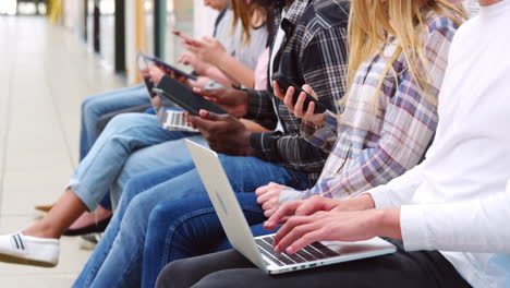 close up of seated college students using digital technology