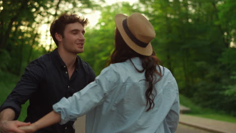 charming man and woman holding hands during walk together outdoors