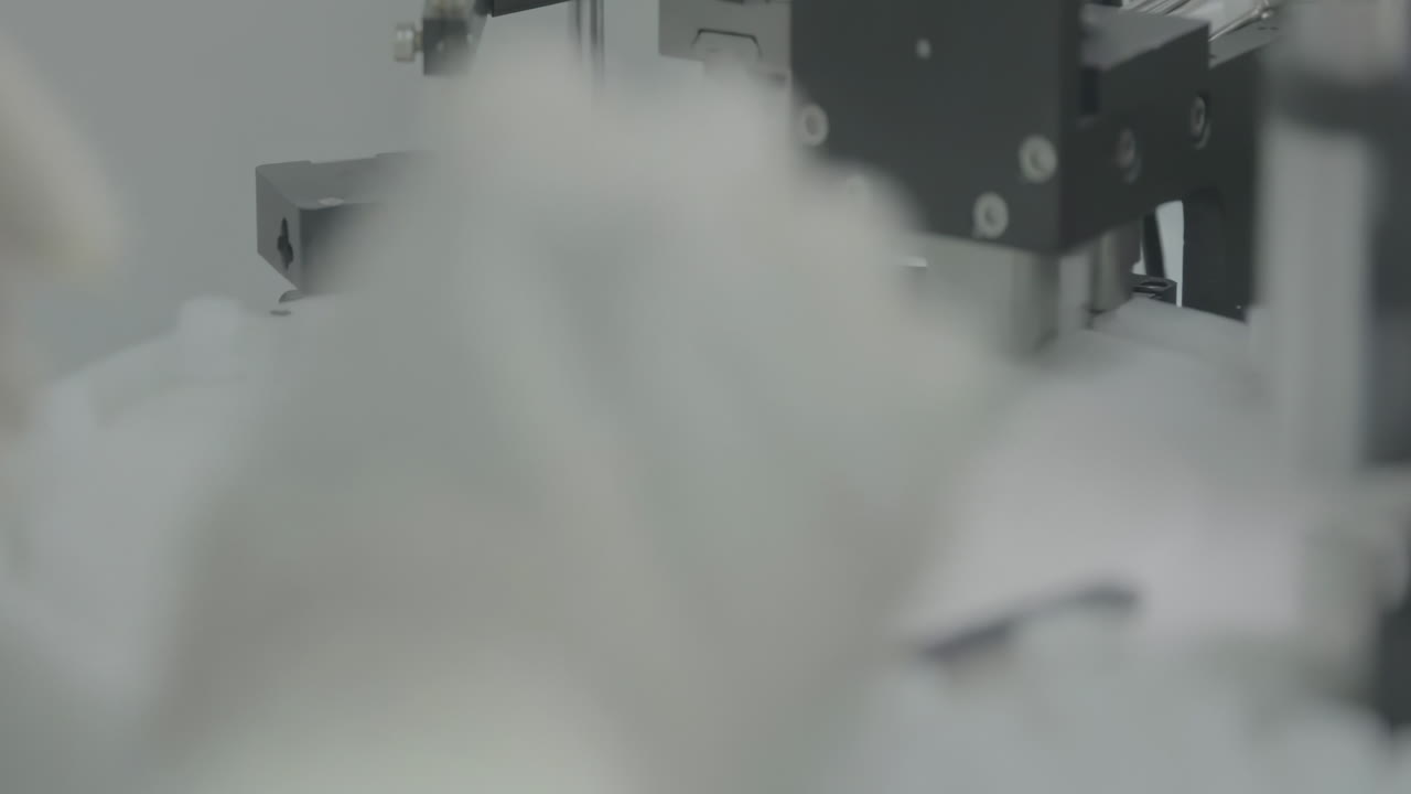 Medical worker controlling production process pharmaceutical production line filling glass vaccine vials with liquid medicine in a sterile drug factory manufacturing environment setting.