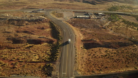 Drone-footage-of-RV-driving-along-road-on-an-American-road-trip-in-Utah-about-to-pull-into-a-service-station