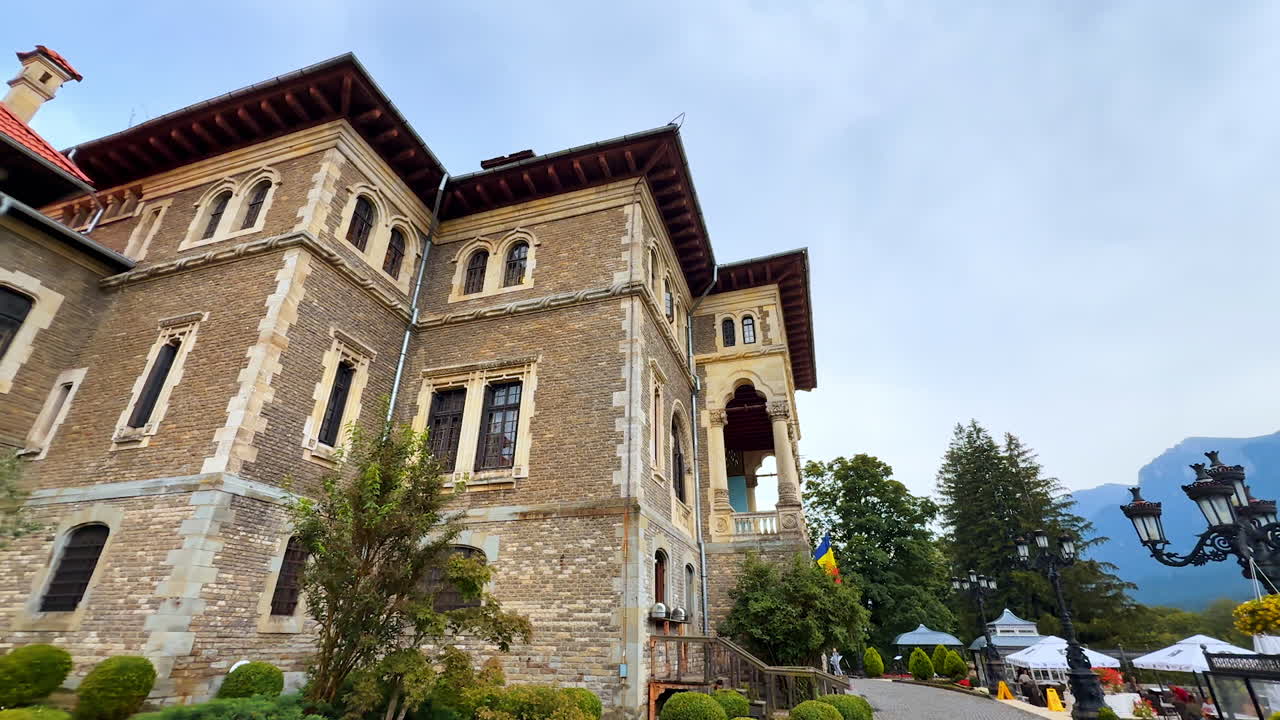 Busteni, Romania, 17 July 2025: Walking around stunning Cantacuzino Castle in Busteni, Romania. Approaching the entrance of the building decorated by the plants