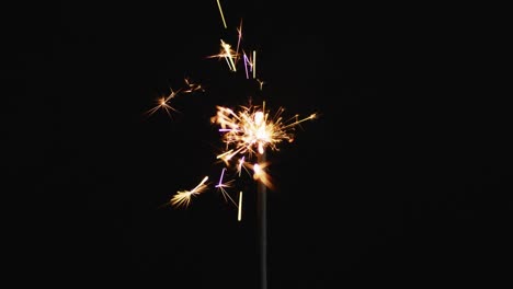 una chispa de fiesta encendida brillando sobre un fondo negro