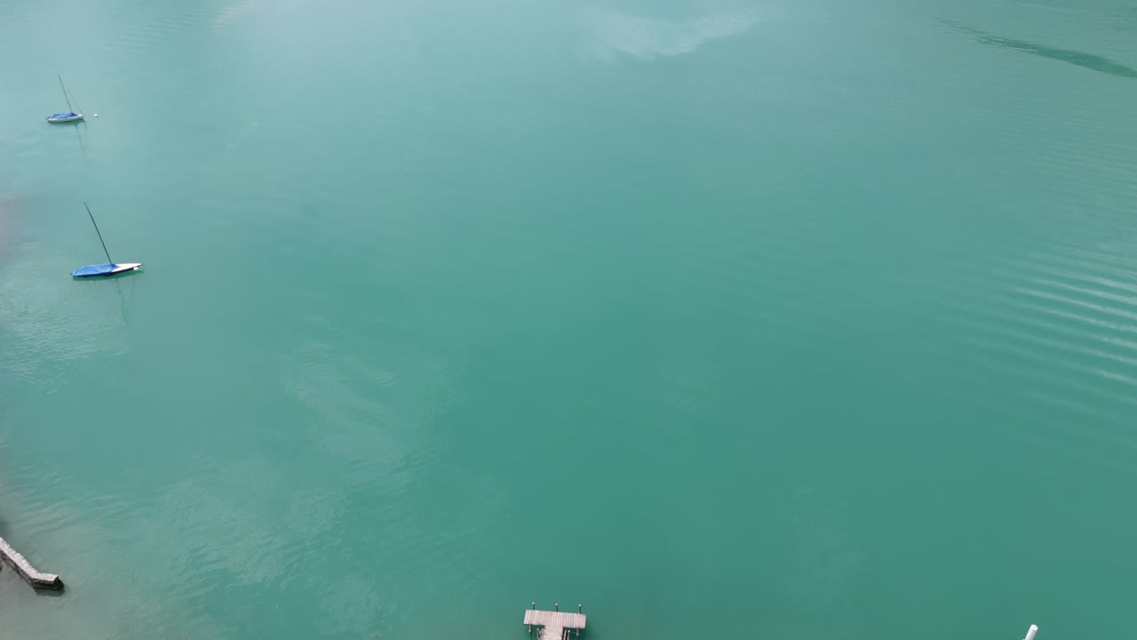 Flying over the famous pier film location of Crash Landing on you revealing the stunning view of the turquoise lake Brienzersee surrounded by the alp mountains near Interlaken Switzerland europe