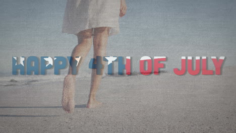 animation of happy 4th of july text with american flag pattern waving over woman walking on beach