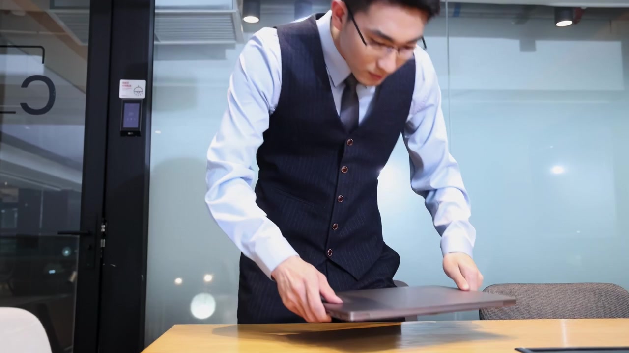 自信に満ちたハンサムなビジネスマンがスーツ姿でノートパソコンを持ち、キーカードをスワイプして電子スマートロック付きの会議室のドアを押し開ける。オンライン通話でビジネスパートナーと会うためのモダンで安全な入室