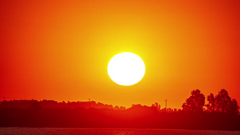 el lapso de tiempo del sol saliendo al amanecer en un cielo rojo