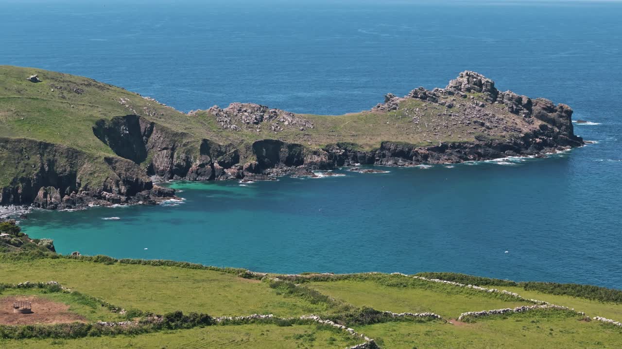Ascending aerial approach to Gurnard’s Head along dramatic Cornwall coast and cliffs, bird's fly above