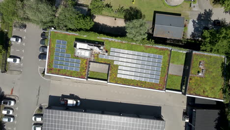antena de arriba hacia abajo de paneles solares en un tejado verde - aterrizaje de drones