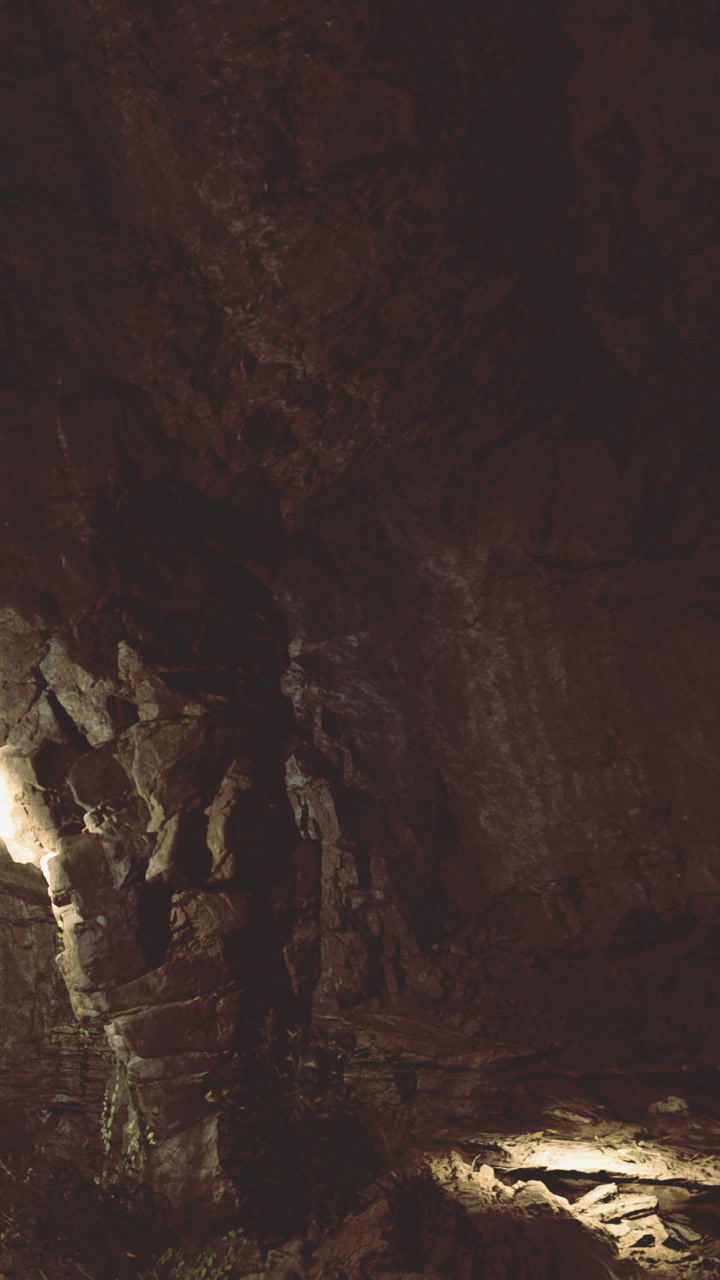 Exploring the dark cave with rocks and light in the foreground