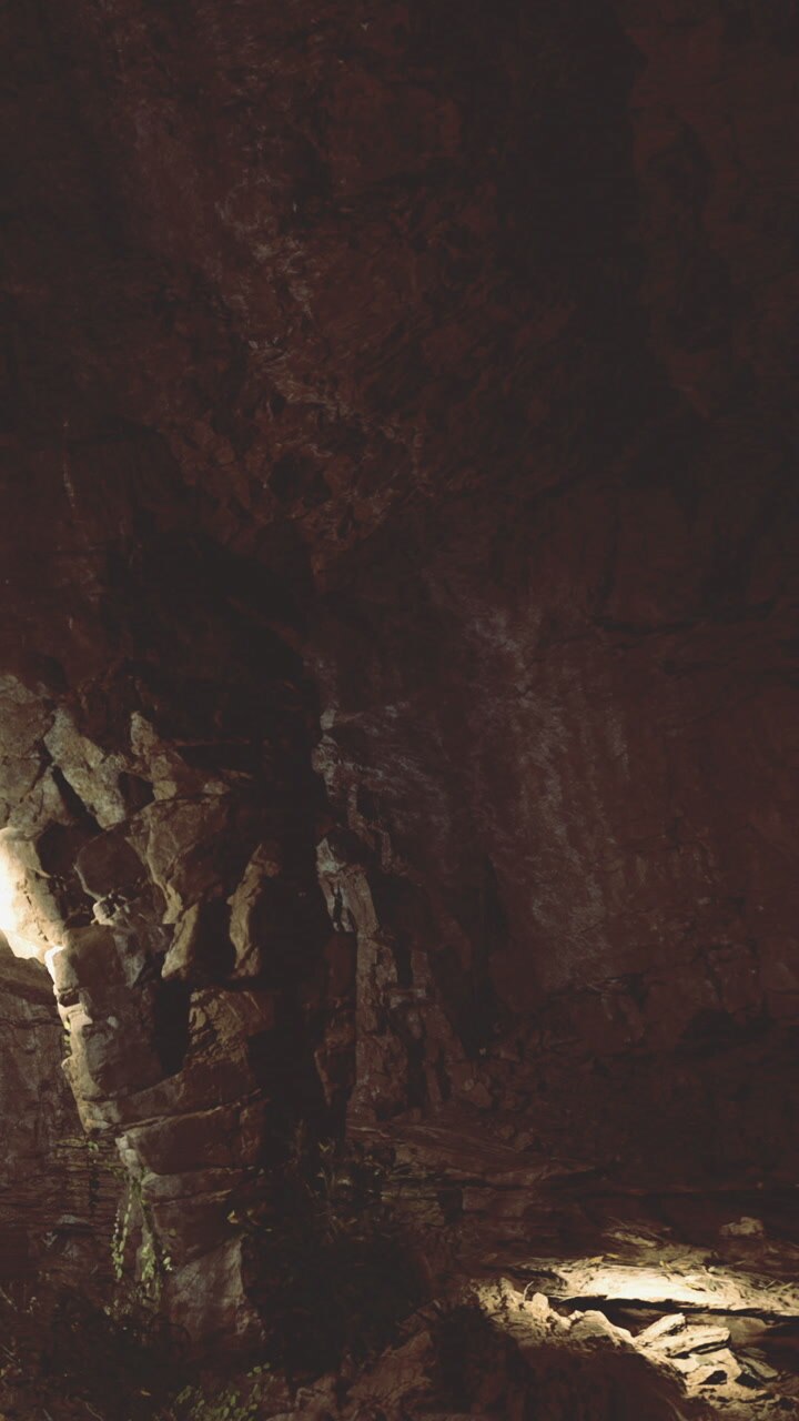 Exploring the dark cave with rocks and light in the foreground