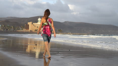 Filmaufnahme-Einer-Frau,-Die-Am-Strand-Von-Las-Canteras-Auf-Der-Insel-Gran-Canaria-Durch-Das-Alfredo-Kraus-Auditorium-Geht-Und-Es-Bewundert