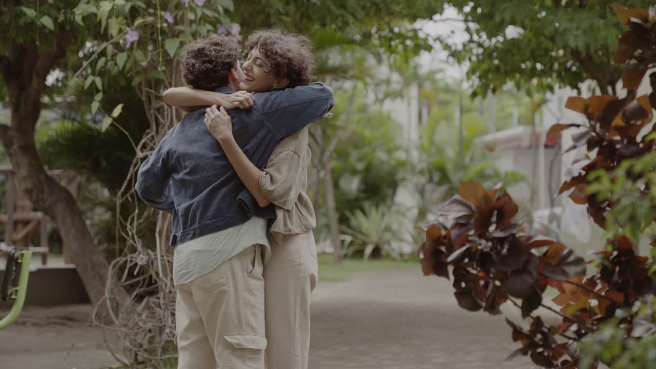 Happy Couple or Friends Hugging and Playing in a Park