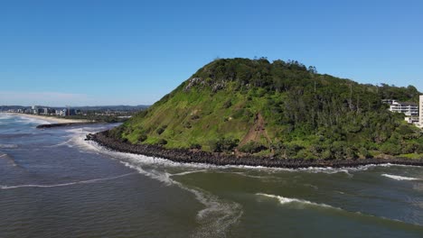 Forested-Burleigh-Hill-With-Rocky-Shoreline-Against-Blue-Sky
