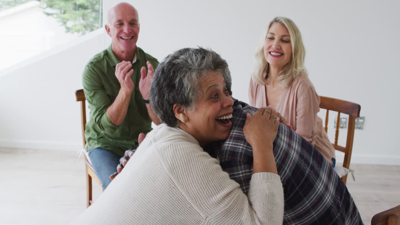 집 에서 치료 대화 를 하는 원 에 앉아 있는 두 명 의 다양한 노인 부부