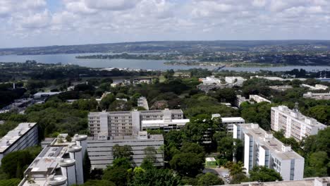 Over-Brasilia-city,-beyond-buildings-and-green-areas,-Paranoá-Lake,-aerial