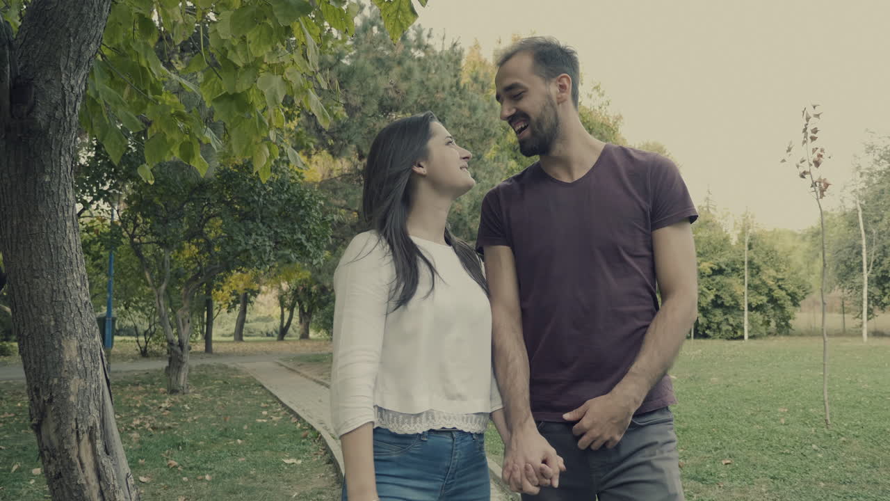 una pareja caminando por el parque.